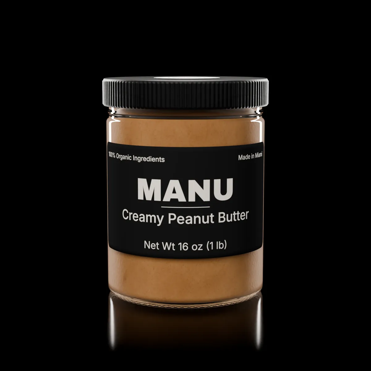 A MANU creamy peanut butter jar on black, front label facing the camera.