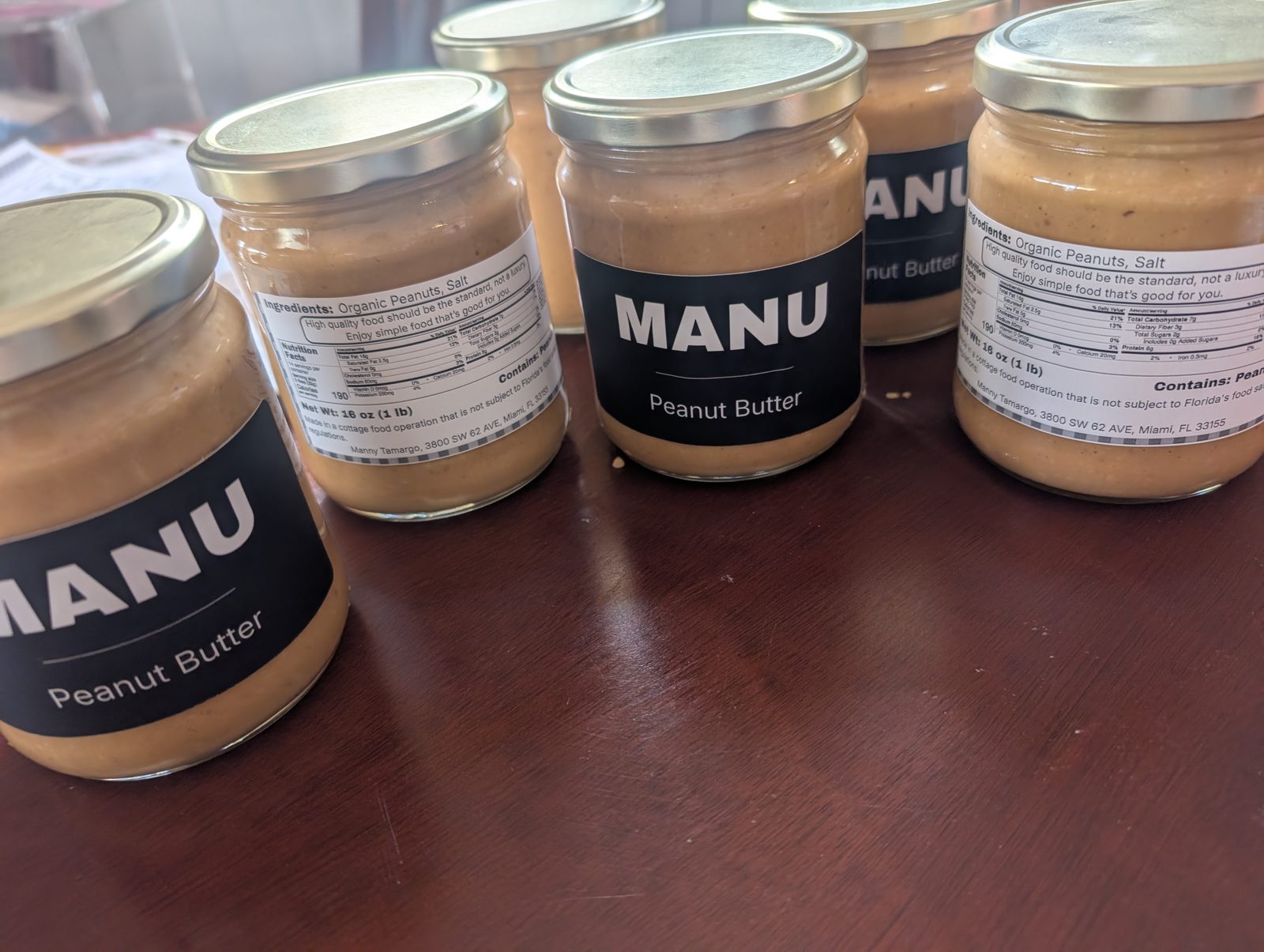 MANU peanut butter jars on a wooden table