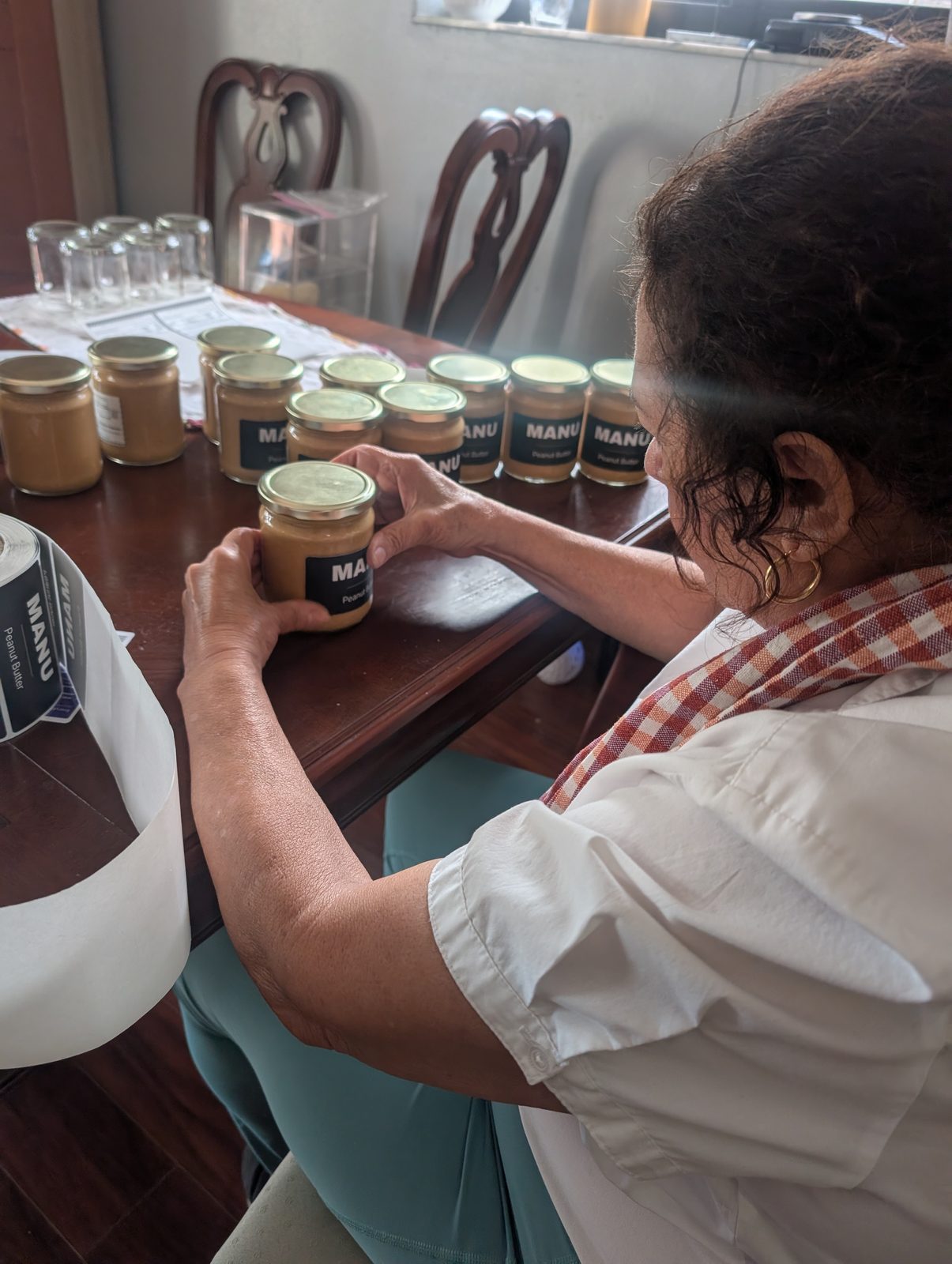 Labelling MANU jars by hand at a table